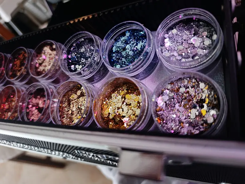 Maletín con glitter cosmético en tonos dorados y rosas