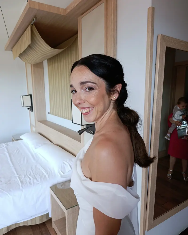 Novia sonriente con maquillaje natural y recogido, maquillada a domicilio en Madrid por Rebeca Sánchez