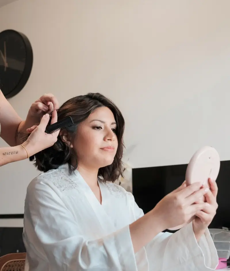 Novia revisando el maquillaje en el espejo durante los preparativos