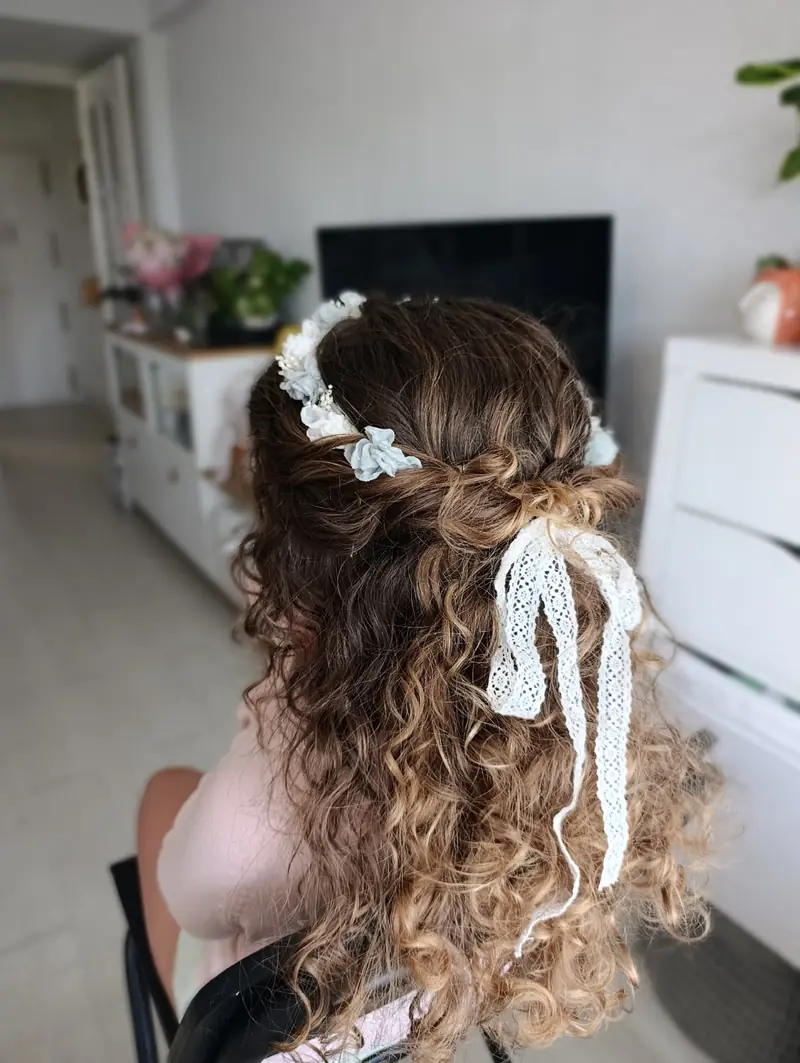 Peinado de niña de comunión con rizos, flores y lazo de encaje